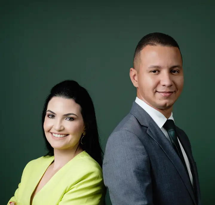 Os sócios do escritório lado a lado: uma advogada de blazer verde-limão e um advogado de terno cinza